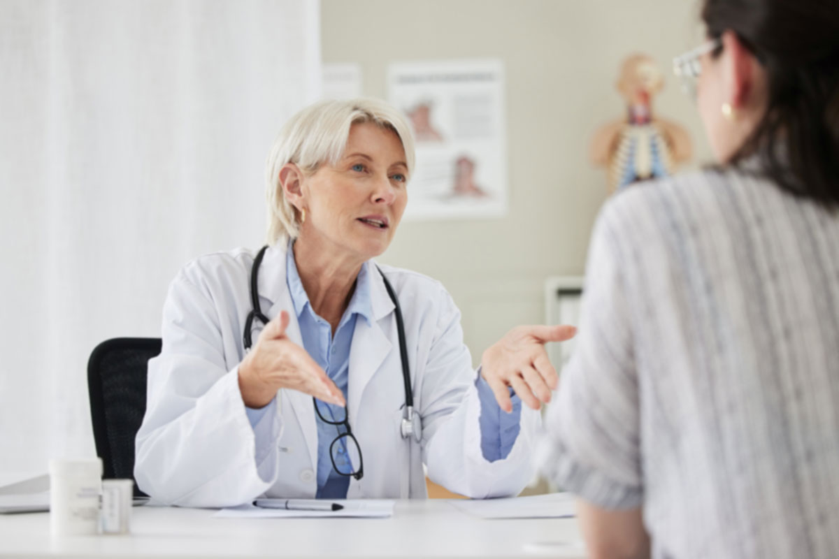 Senior, doctor and patient for consultation at the clinic about health condition and wellness. Medical, professional and women with communication at hospital in the office about medicine and surgery.