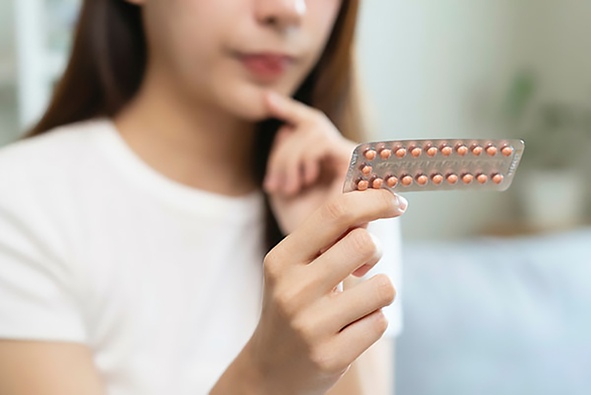 Young female holding birth control pills.